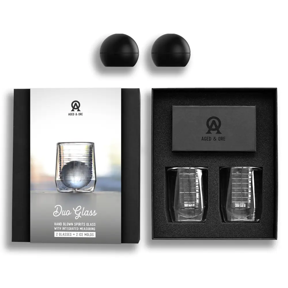 Aged & Ore Duo Glass, a double-wall glass holding a bourbon Old Fashioned with a large ice ball