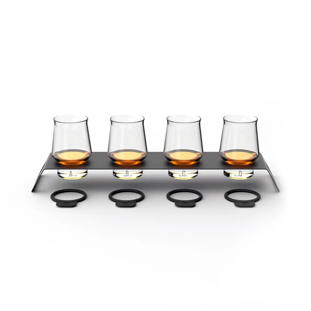 Aged & Ore Spirits Flight, four crystal tasting glasses on a wall-mounted aluminum tray