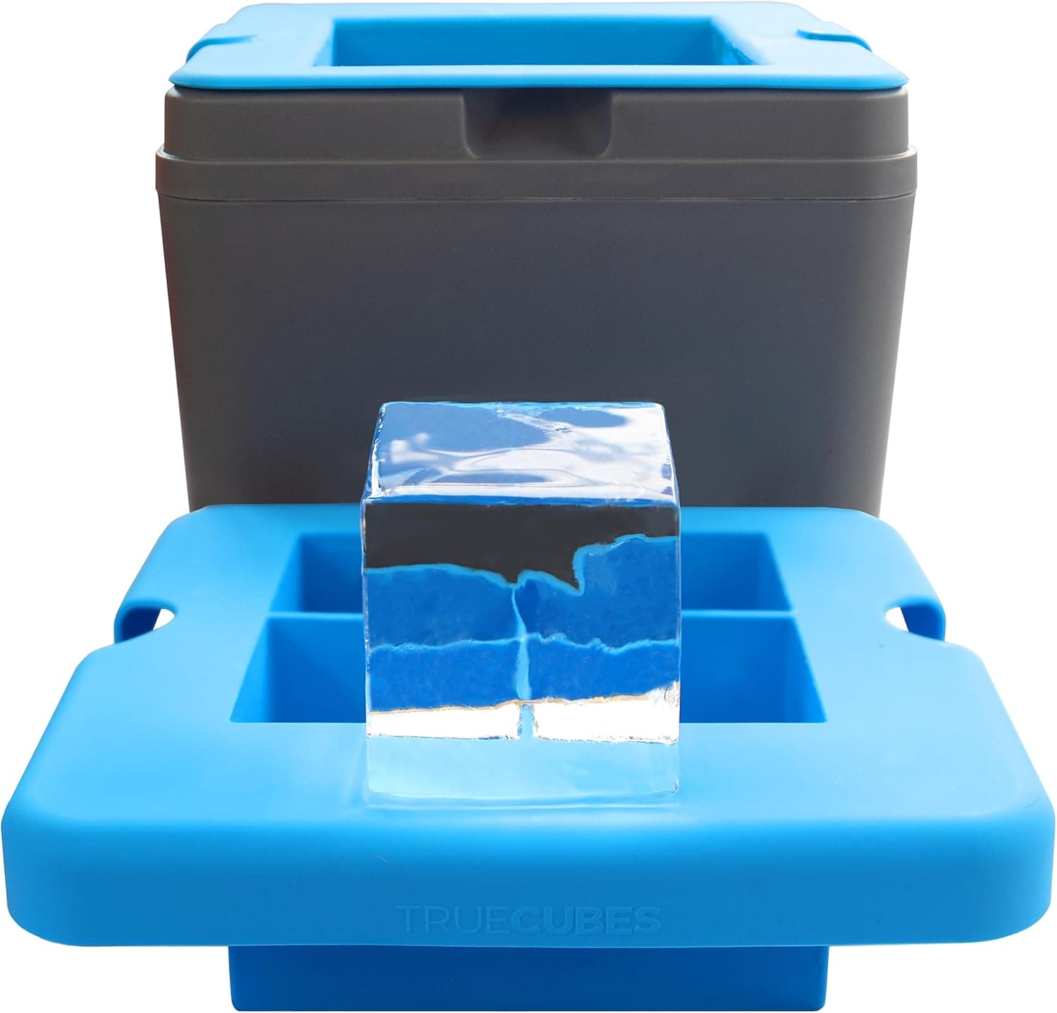 True Cubes insulated silicone mold and grey freezing housing beside a flawless two-inch clear ice cube