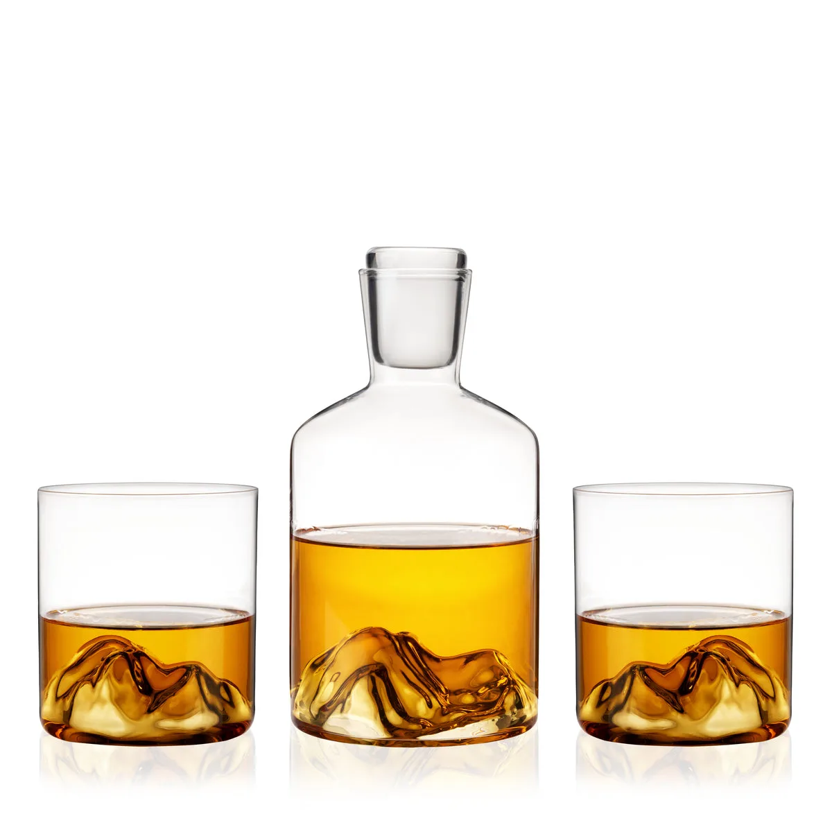 Viski Mountain crystal decanter and two tumblers with hand-blown mountain-shaped bases, filled with whiskey