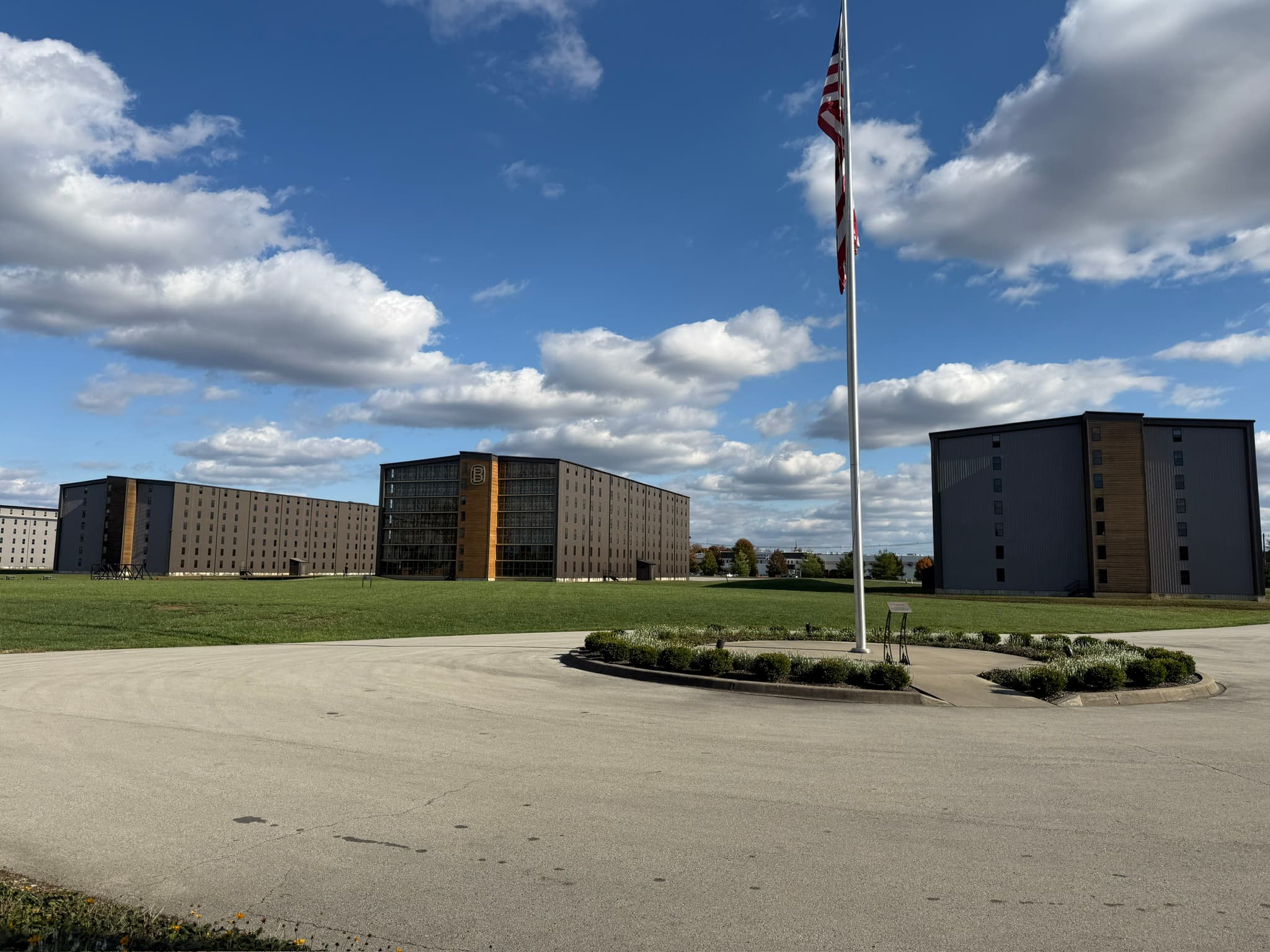 The modern glass and steel distillery building at Bardstown Bourbon Company under an overcast sky