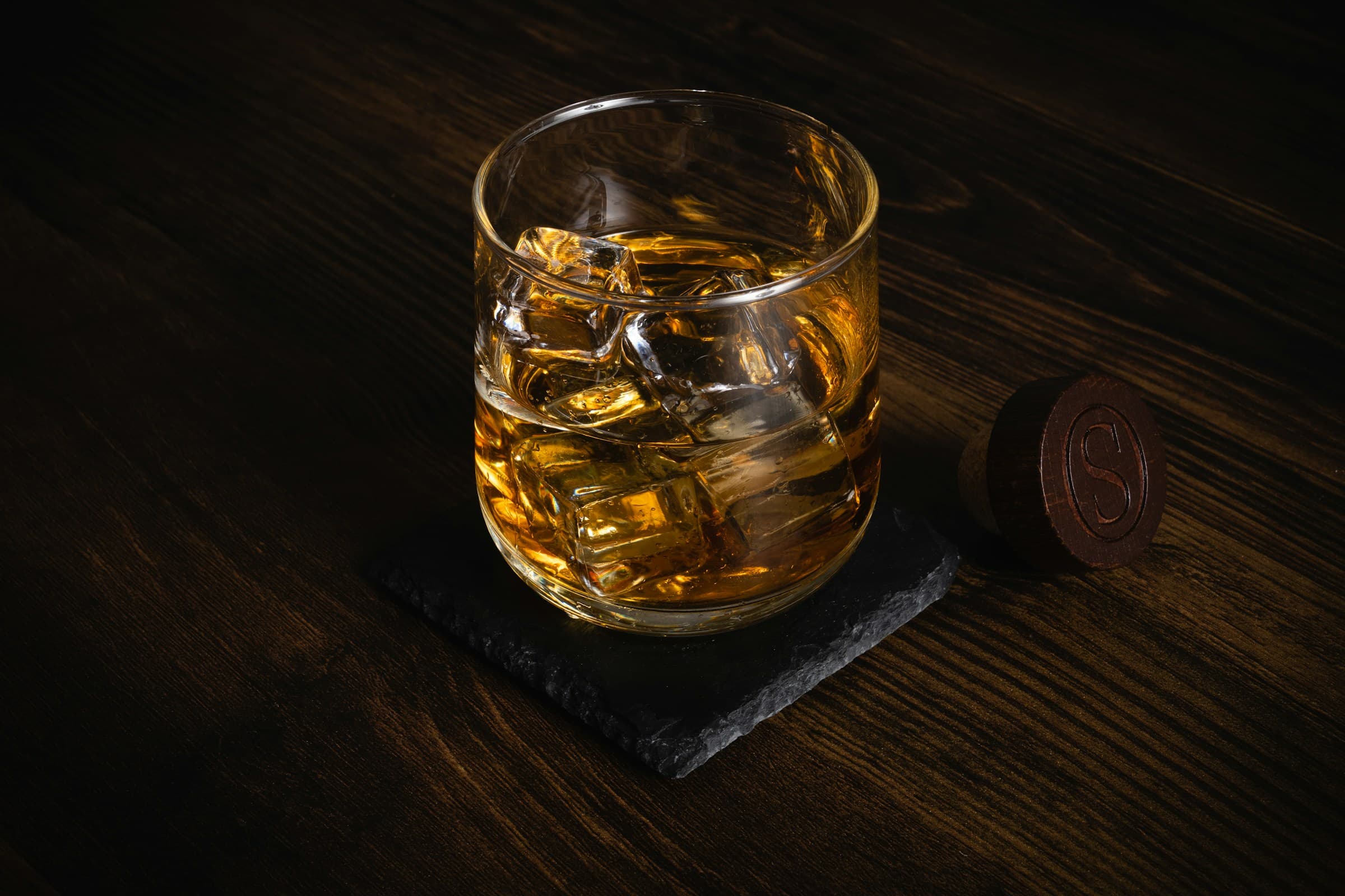 Premium bourbon in a crystal glass on a dark wood surface